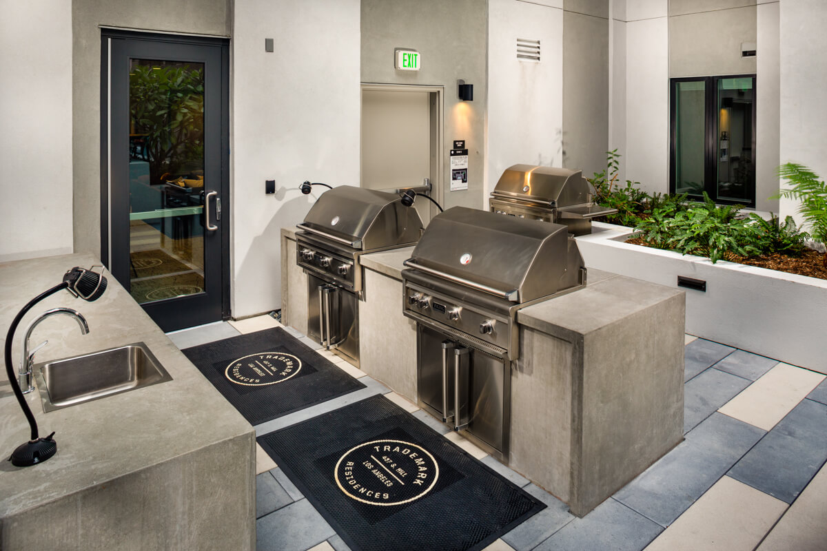 Downtown Los Angeles CA Apartments - Trademark Residences - Outdoor Grill Area wit Multiple Grills, Lighting, and Prep Station with Sink.